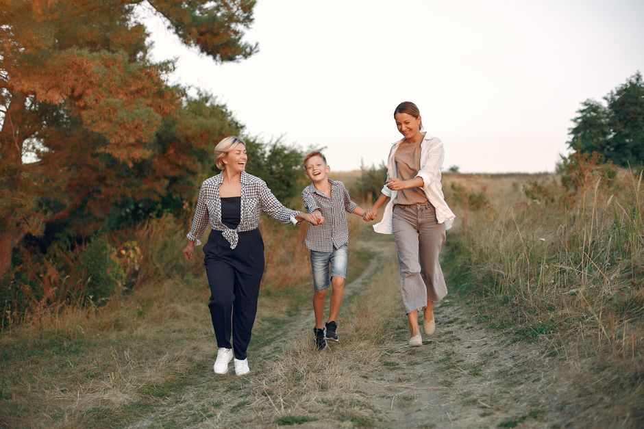 Trois générations d'une même famille se promenant dans la campagne, transmission familiale accompagnée par un notaire à Bessières